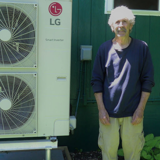 A man stands next to a double stack of LG outdoor heat pump units.